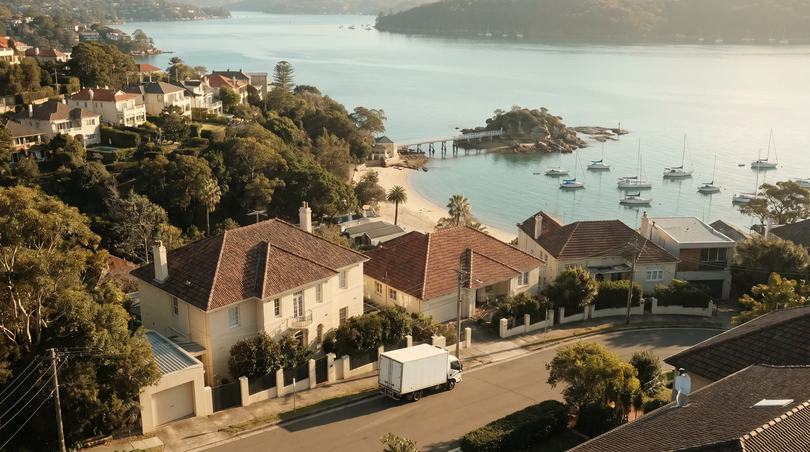 Looking from the ridge over terracotta roofs down to Balmoral Beach, Rocky Point Island and its footbridge